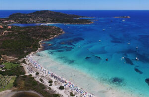 Panorama mozzafiato di Cala Brandinchi, con acque cristalline e sabbia bianca, ideale per una giornata di relax. Prenota il tuo posto per vivere un'esperienza esclusiva sulla spiaggia nel 2025.